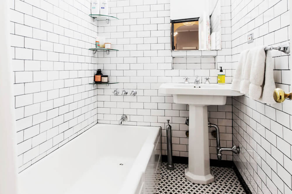 Salle de bain avec carrelage métro blanc, lavabo et baignoire