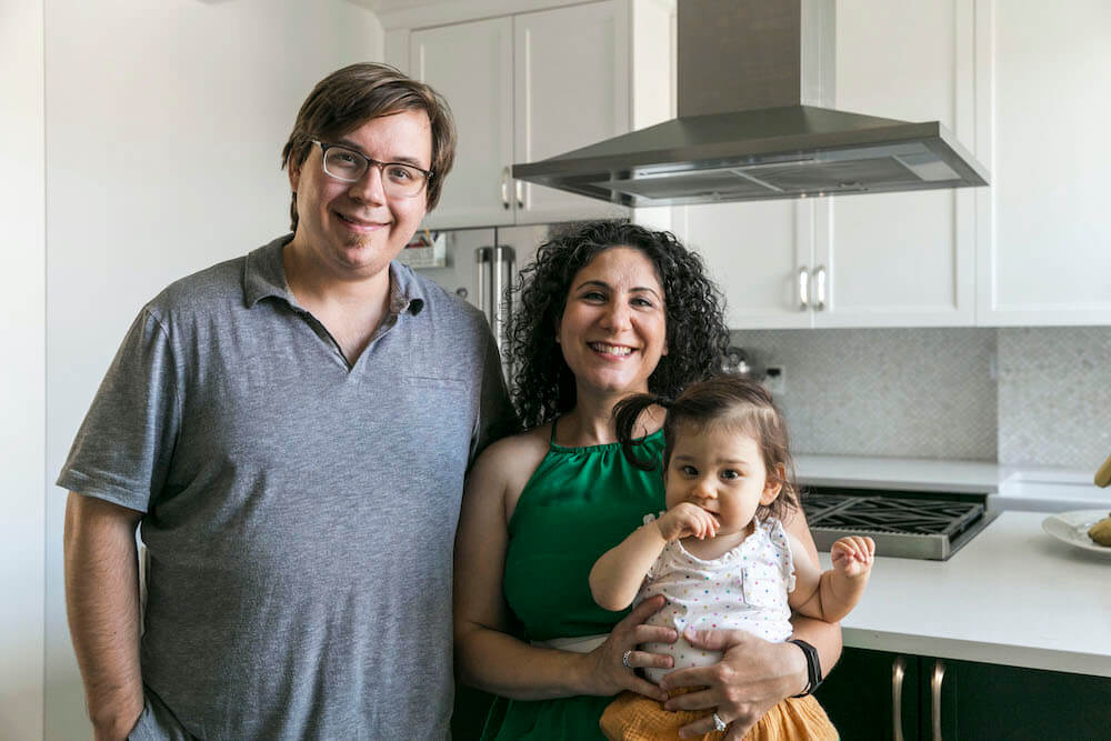 Portrait des propriétaires de Sweeten et de leur bébé dans leur cuisine rénovée